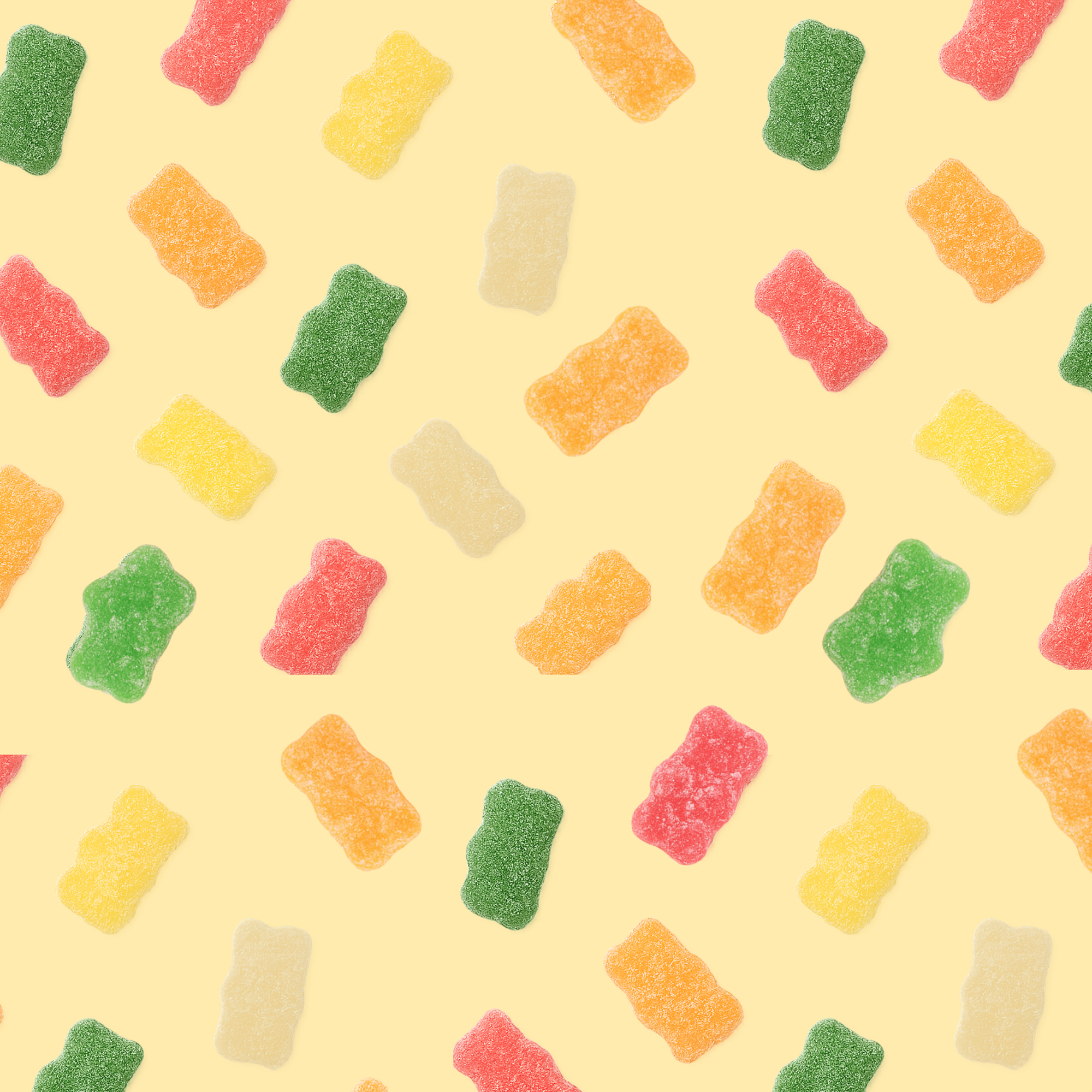 Pattern of colorful gummy bears on a yellow background