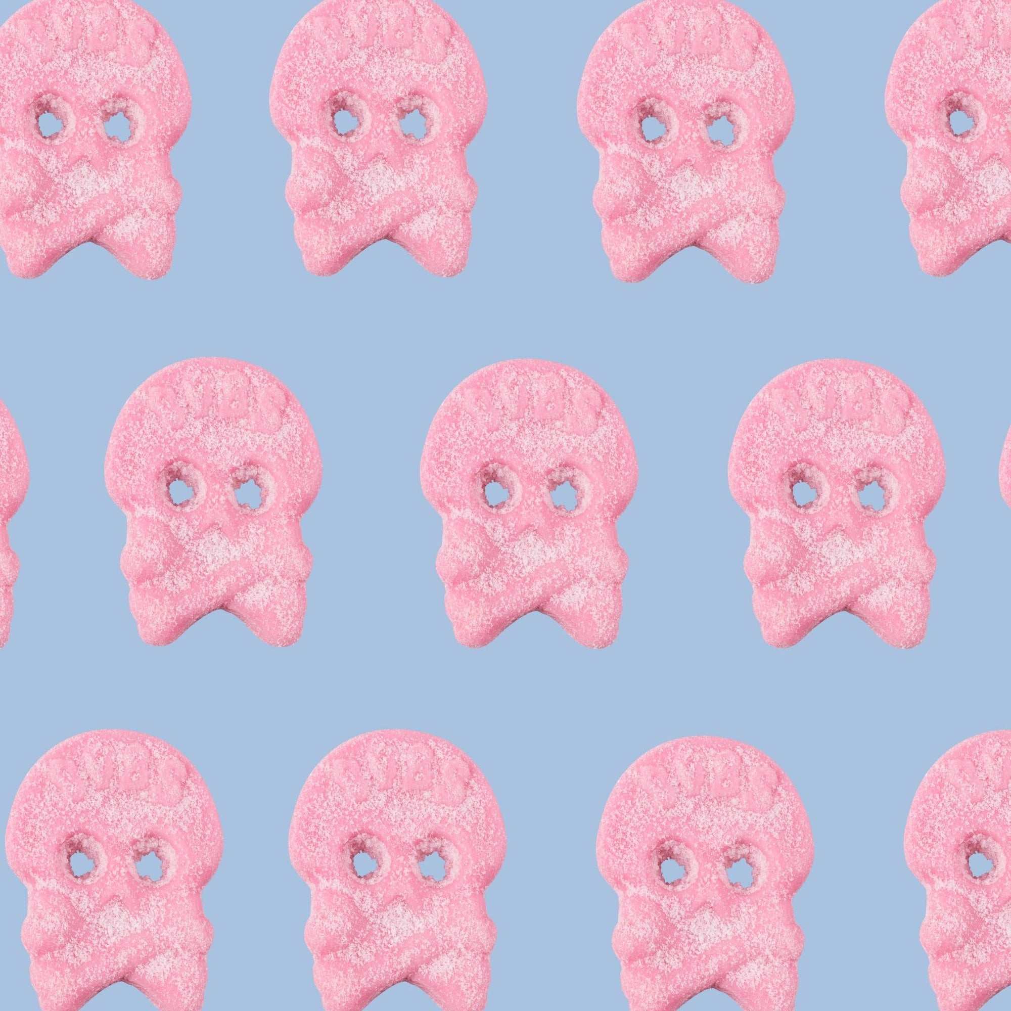 Pattern of pink ghost-shaped cookies on a light blue background