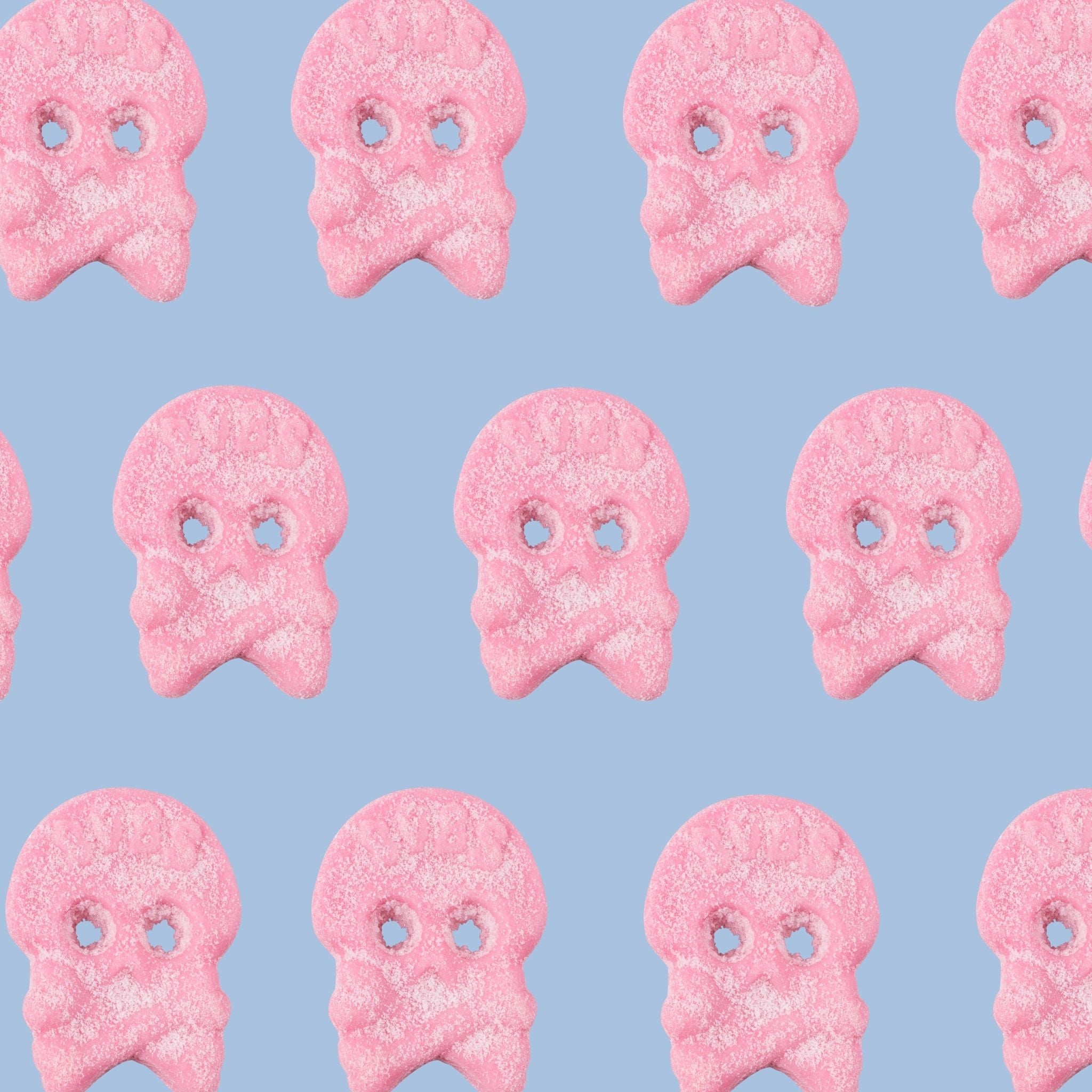 Pattern of pink ghost-shaped cookies on a light blue background