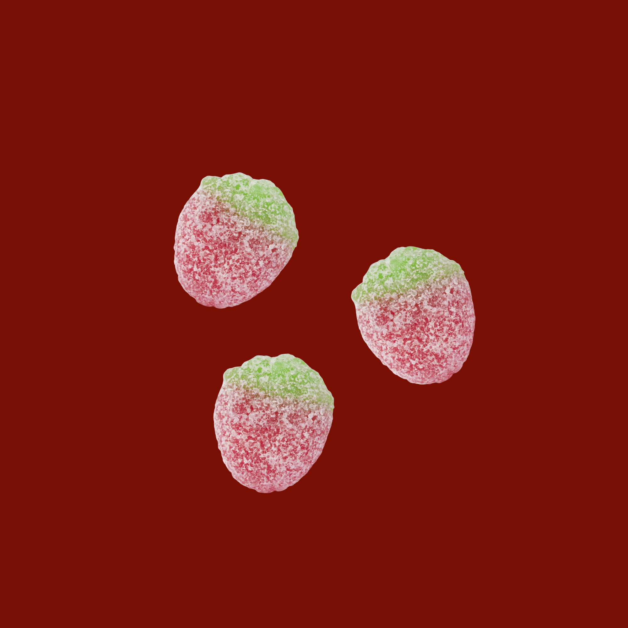 Three red and green gummy candies on a red background