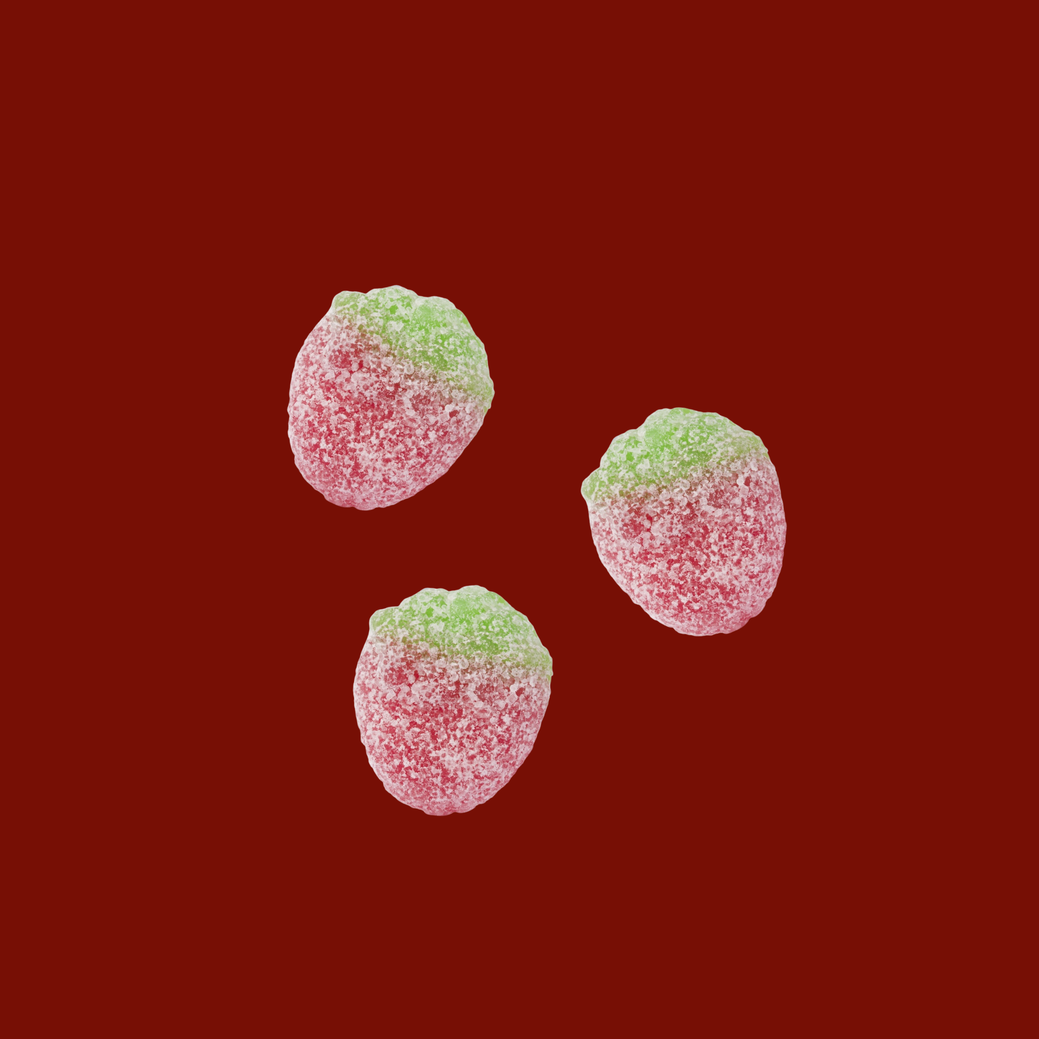 Three red and green gummy candies on a red background