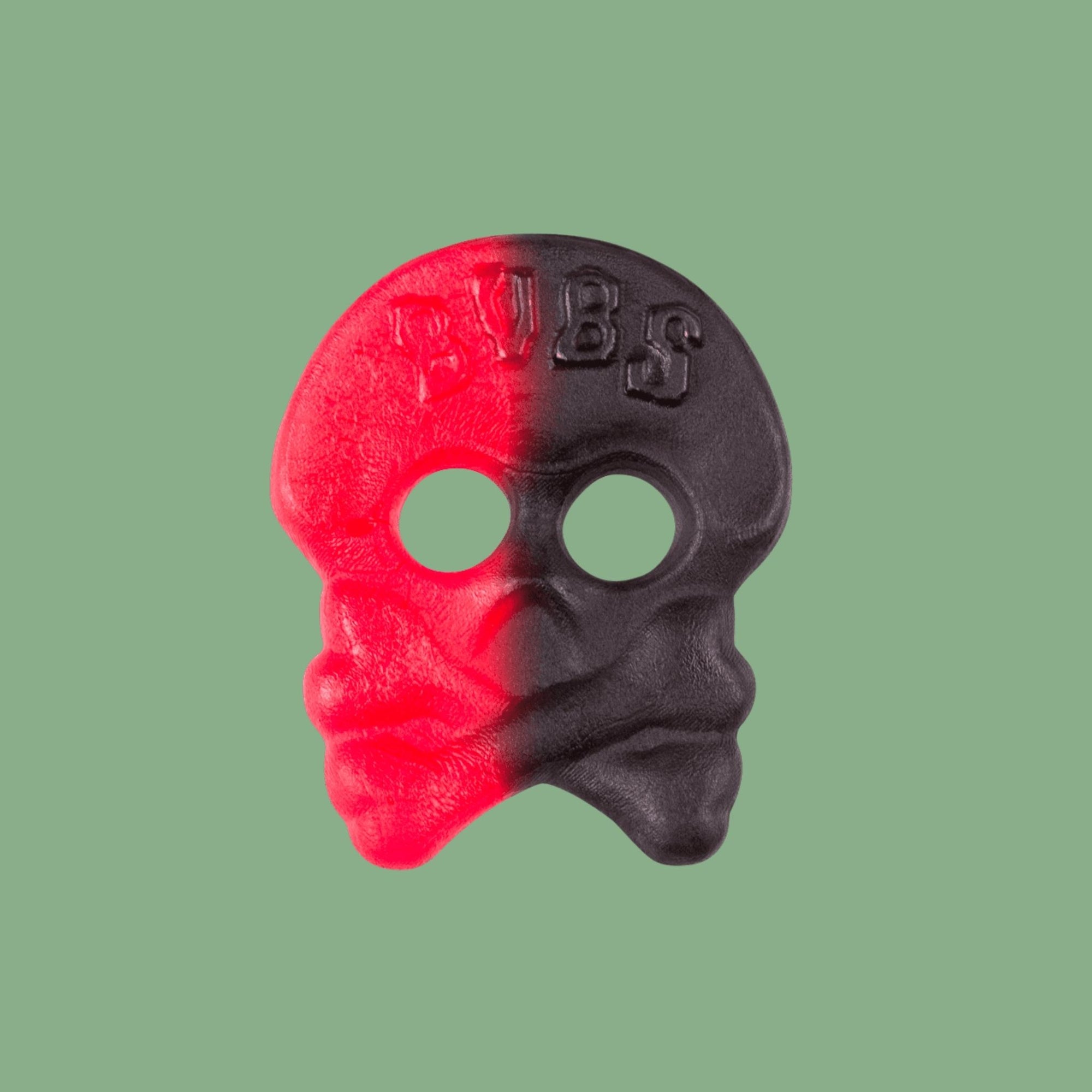 Red and black plastic tool with a face design on a green background