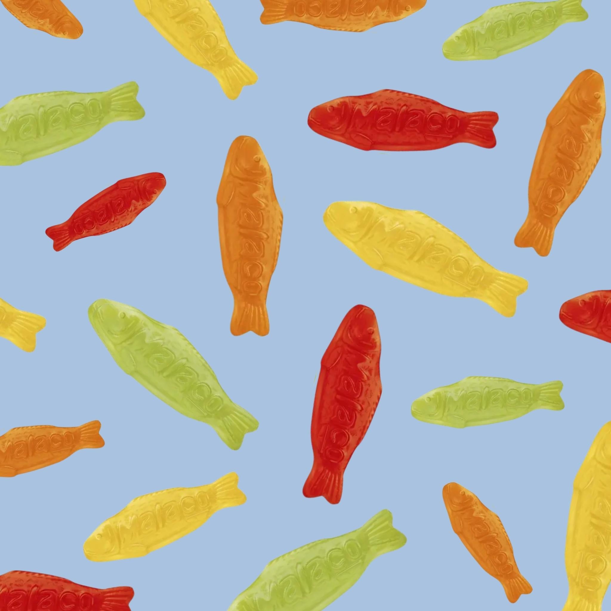 Pattern of colorful fish-shaped candies on a blue background