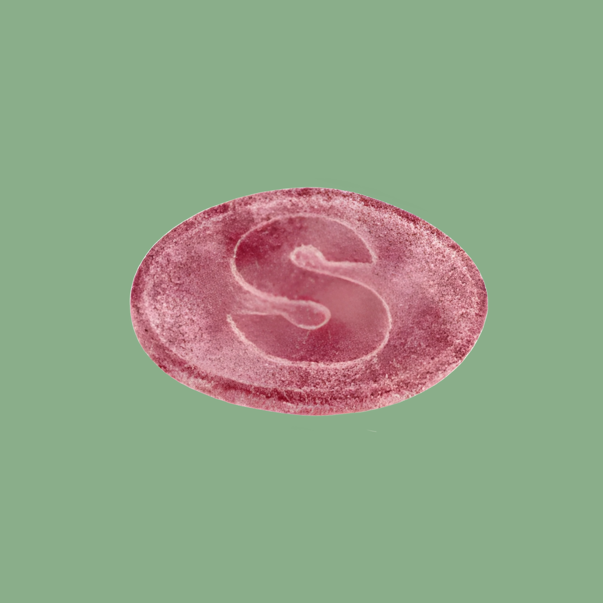 Pink circular object with a letter 'S' on a green background